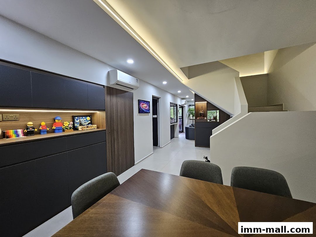 Interior view of a modern home with a dining table, sleek cabinets, and a staircase.