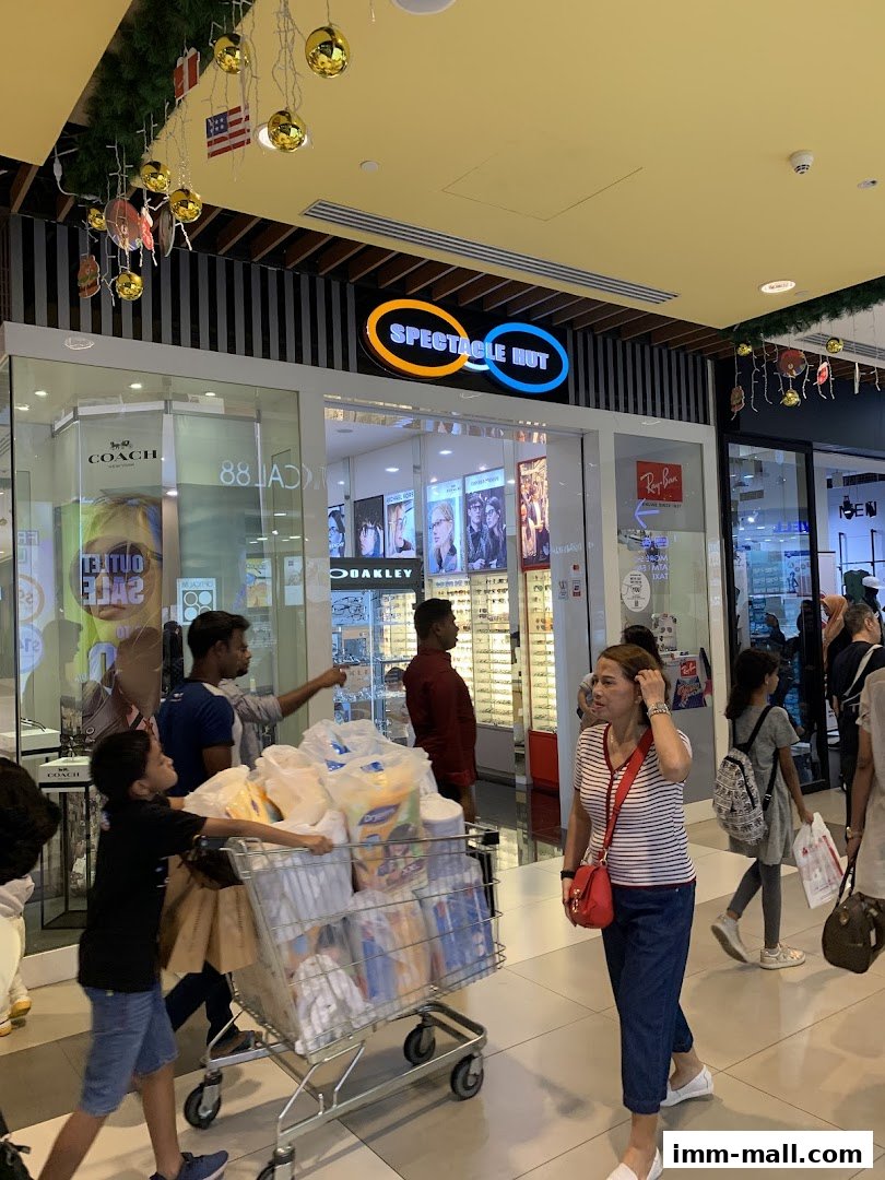 The Spectacle Hut shop front with various eyewear displays and shoppers.