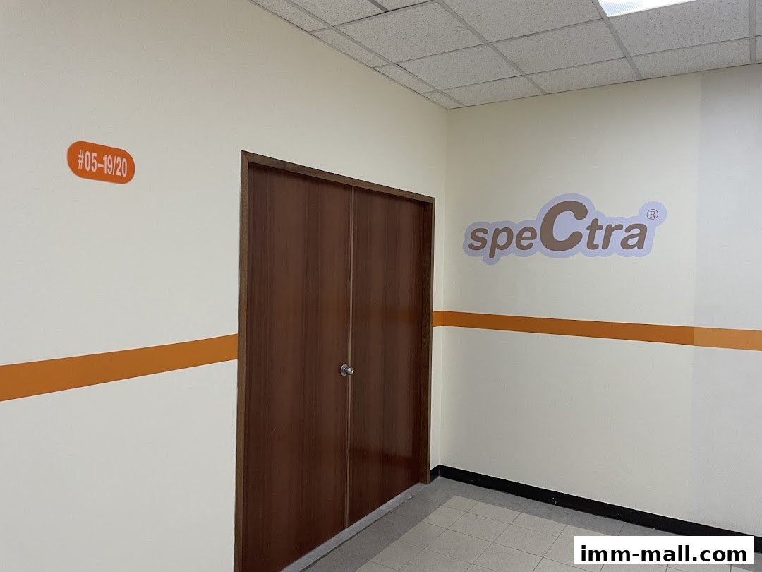 A hallway with a double door and the Spectra logo on the wall.