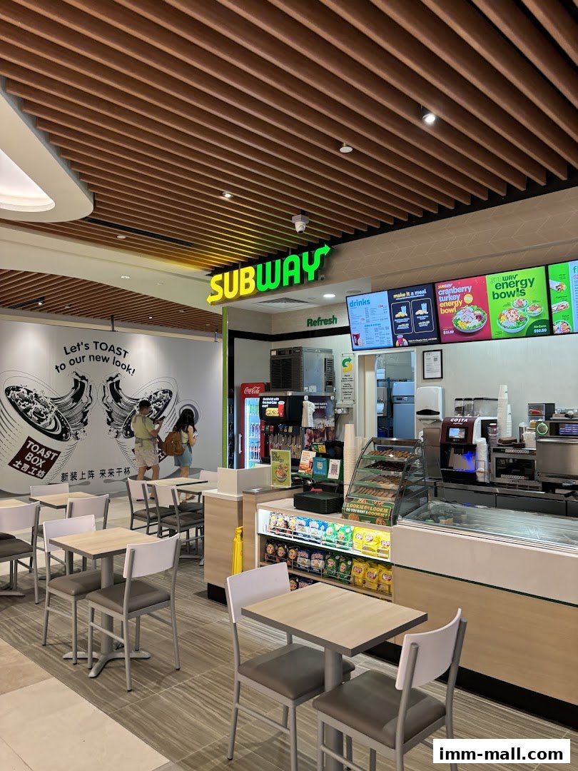 Interior view of a Subway restaurant with seating, counter, and menu displays.