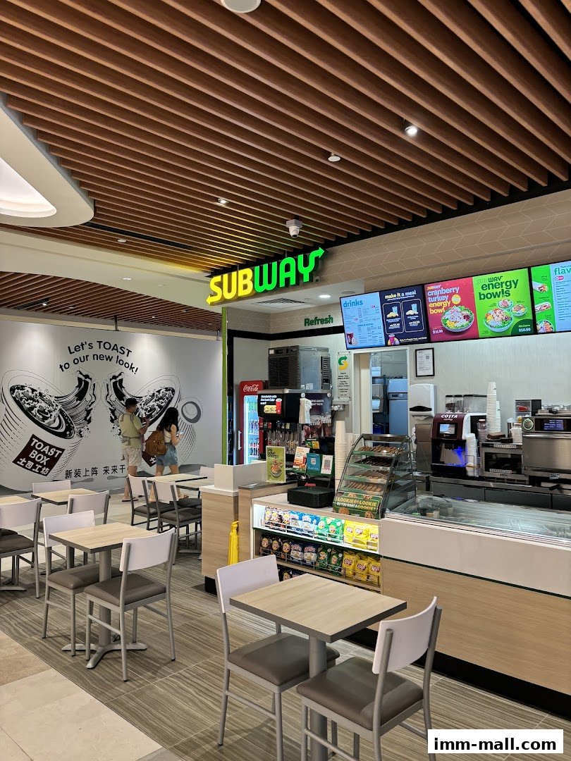 Interior view of a Subway restaurant with seating, counter, and menu displays.