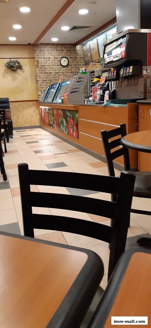 Interior view of a Subway restaurant with seating and a food counter.