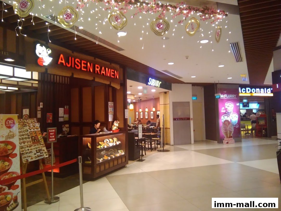 A view of a mall corridor with several fast-food restaurants including Ajisen Ramen, Subway, and McDonald's.