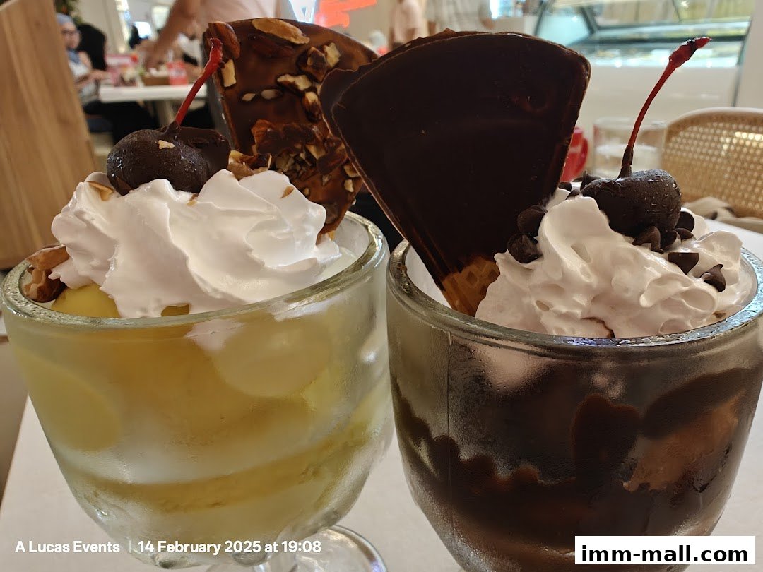 Two delicious ice cream sundaes topped with whipped cream, cherries, and chocolate.