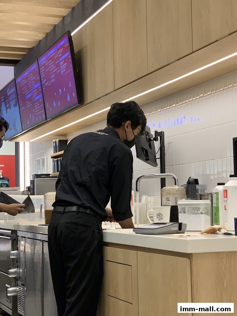 A barista in a black uniform works behind the counter at The Coffee Bean Tea Leaf.