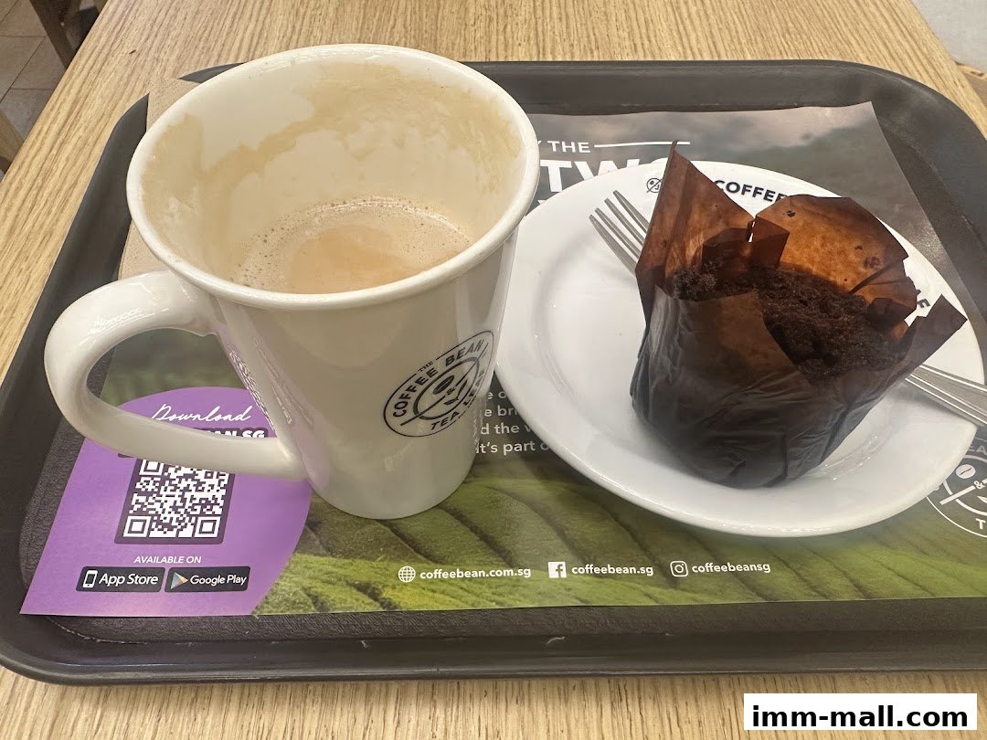 A coffee mug and a chocolate muffin on a tray at The Coffee Bean & Tea Leaf.