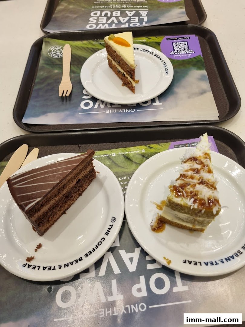 Three slices of cake are displayed on plates with wooden forks on trays.