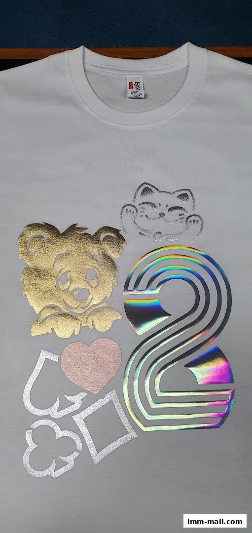 A white t-shirt with various holographic and metallic foil designs, including a bear, cat, heart, and playing card suits.
