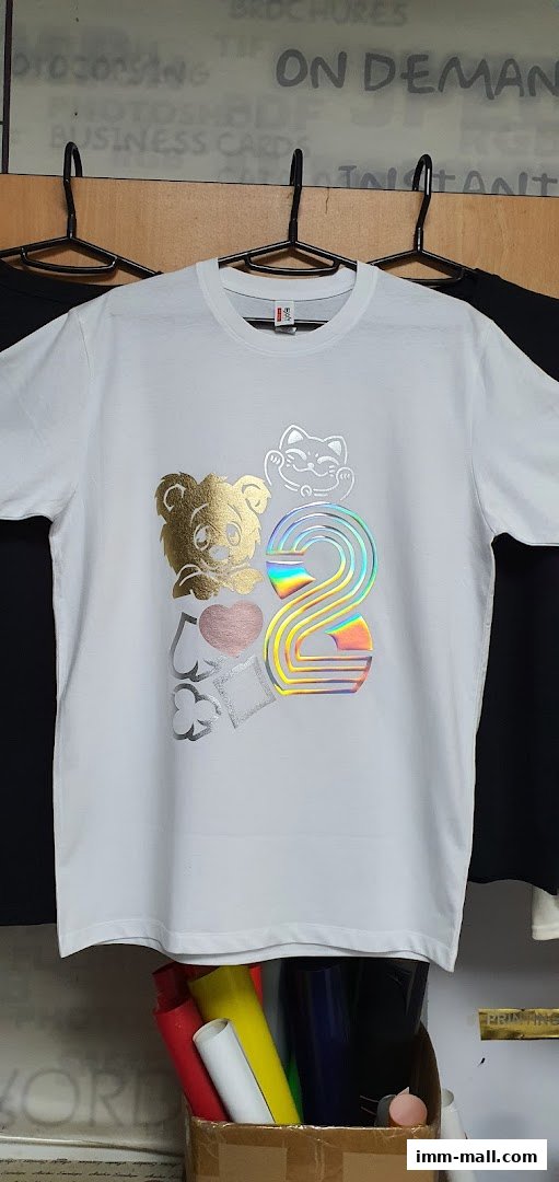 A white t-shirt with a colorful graphic design featuring a lion, lucky cat, and the number 2.