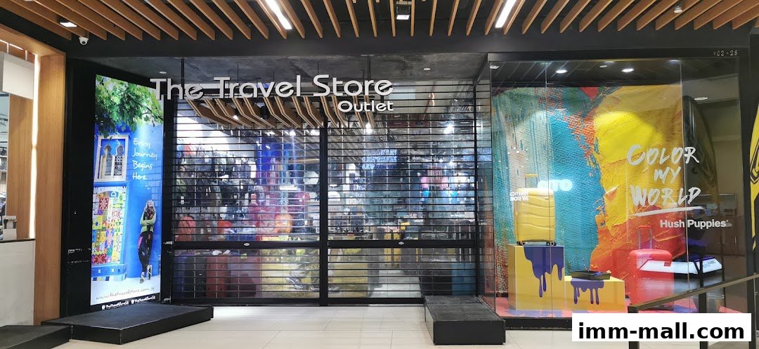 The Travel Store outlet storefront with a closed roller shutter and colorful window displays.
