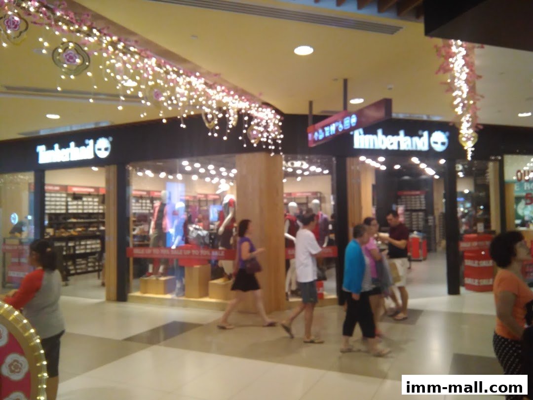 The Timberland store entrance with mannequins and sale signs, bustling with shoppers.