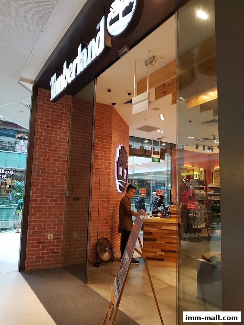 The Timberland store entrance with a brick wall, signage, and a cashier counter visible inside.