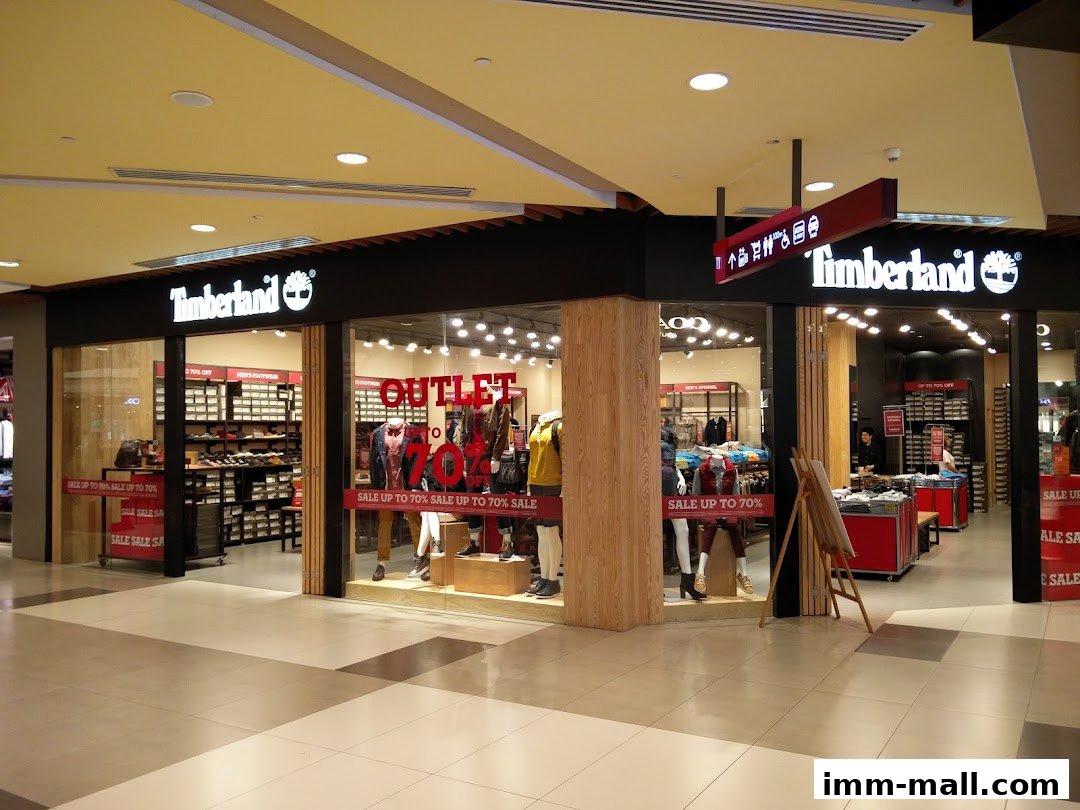 The Timberland store features a large display window showcasing apparel and footwear, with an "OUTLET" sign.