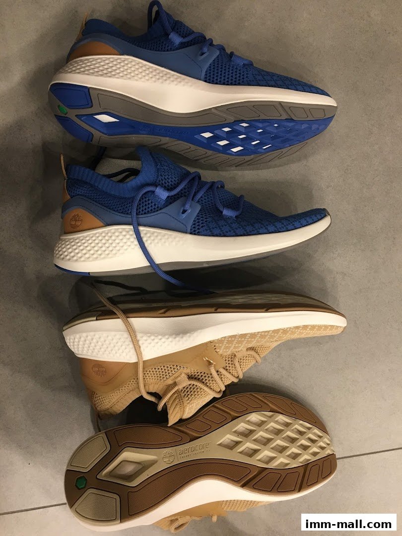 A top-down view of two pairs of Timberland sneakers, one blue and one tan.