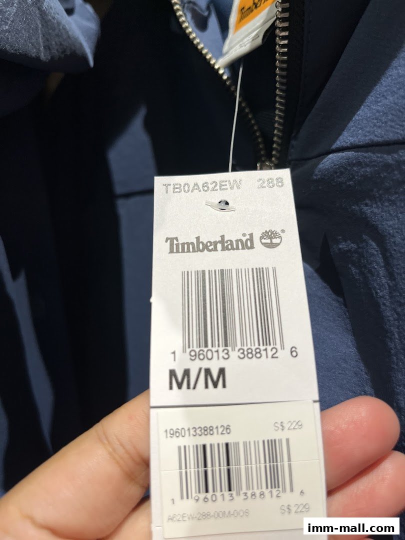 A close-up of a Timberland clothing tag showing product details and price.