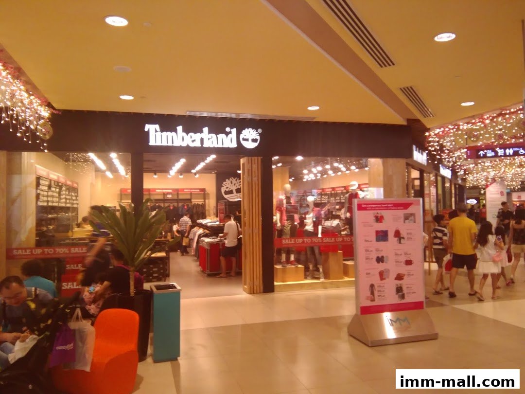 The Timberland store entrance with a sale sign and people browsing inside.