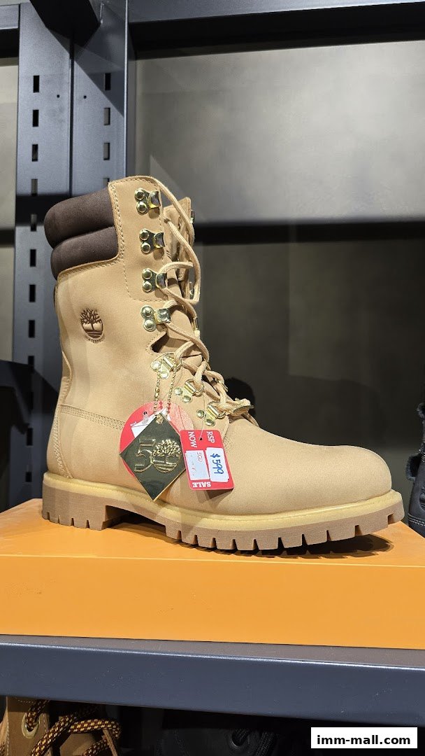 A close-up of a tan Timberland boot with gold hardware and sale tags.