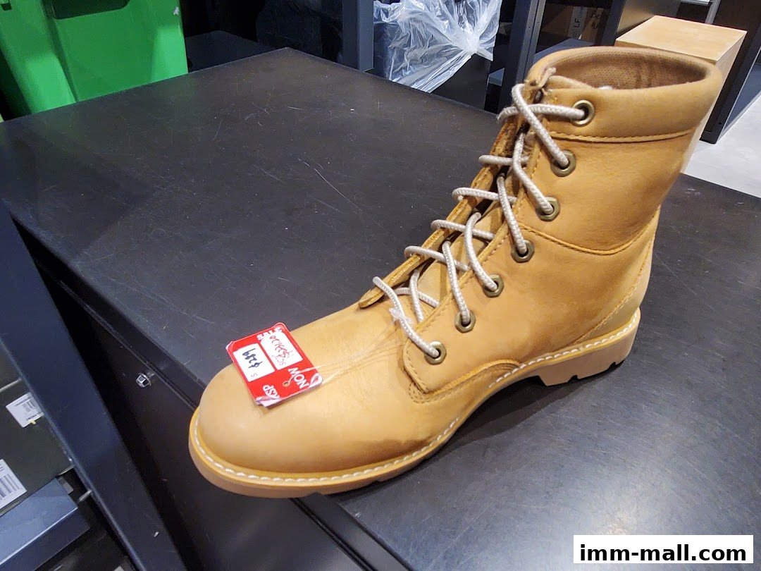 A tan Timberland boot with a red price tag is displayed on a black surface.