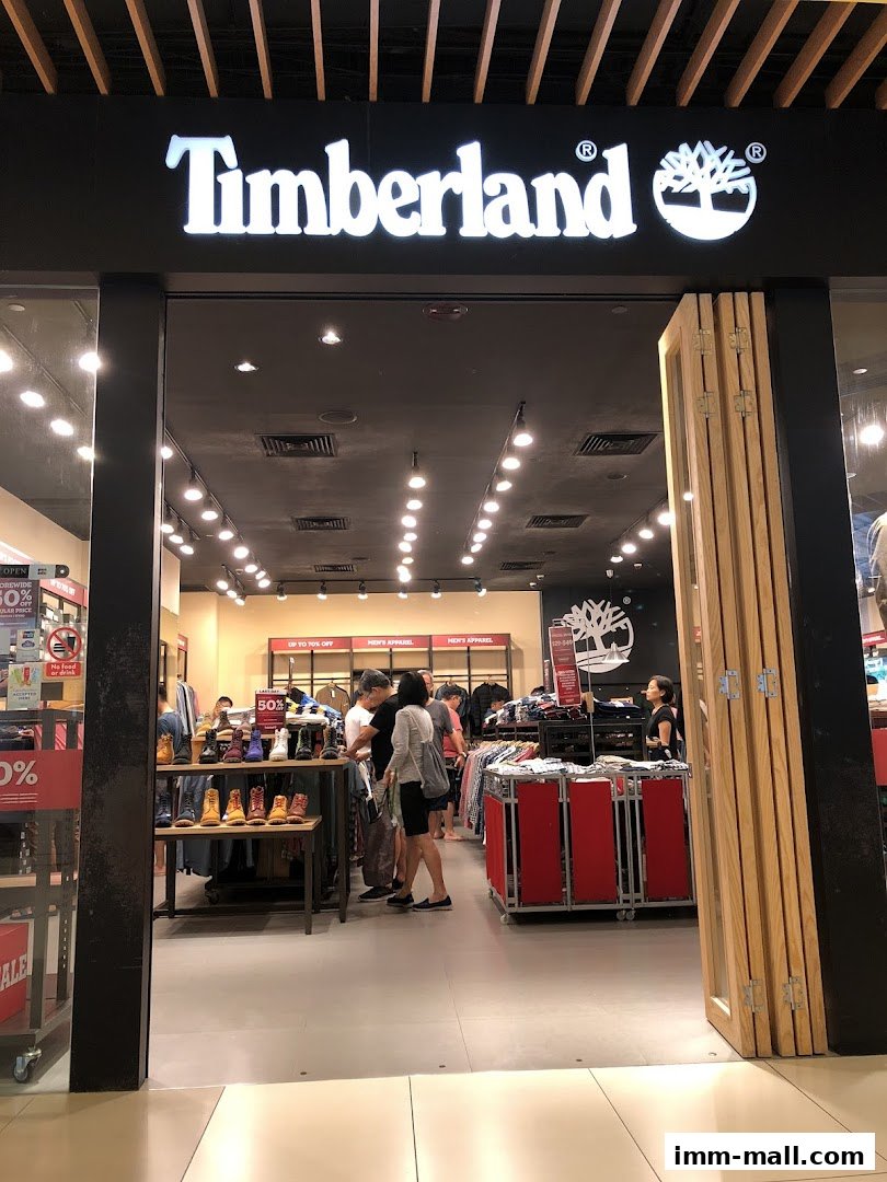The entrance of a Timberland store showcasing boots and apparel with sale signs.