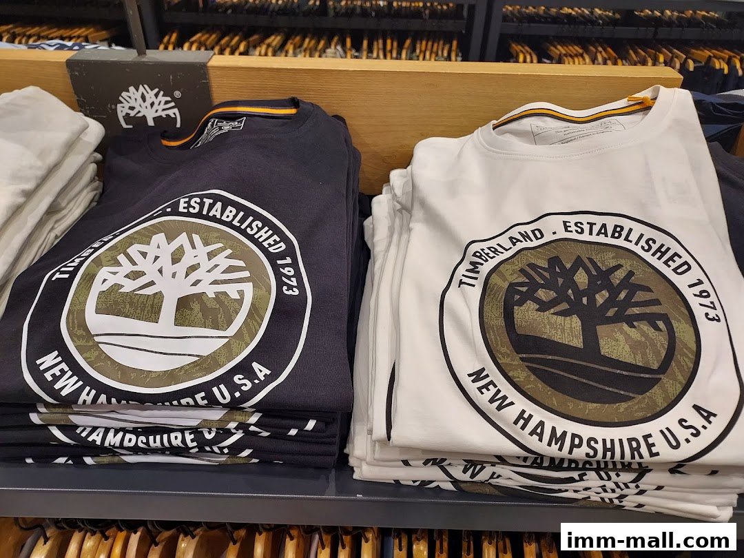 Neatly folded Timberland t-shirts in black and white with the brand's iconic tree logo.