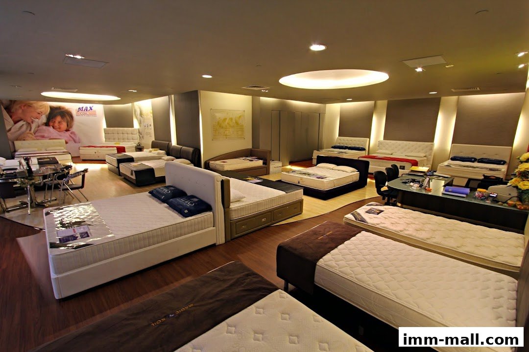 A well-lit showroom displaying a variety of beds and mattresses.
