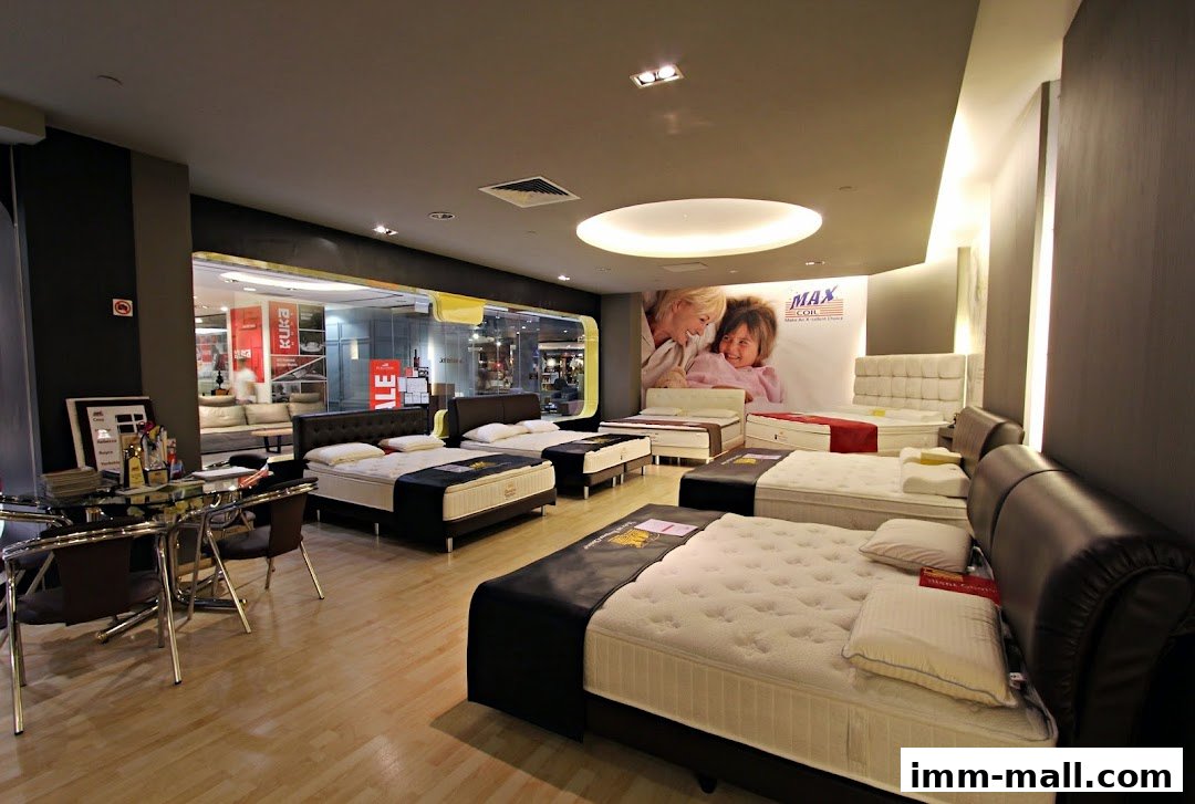 Interior view of a mattress store showcasing various beds and a seating area.