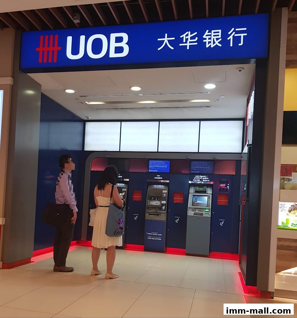 A UOB ATM counter with two people waiting to use the machines.