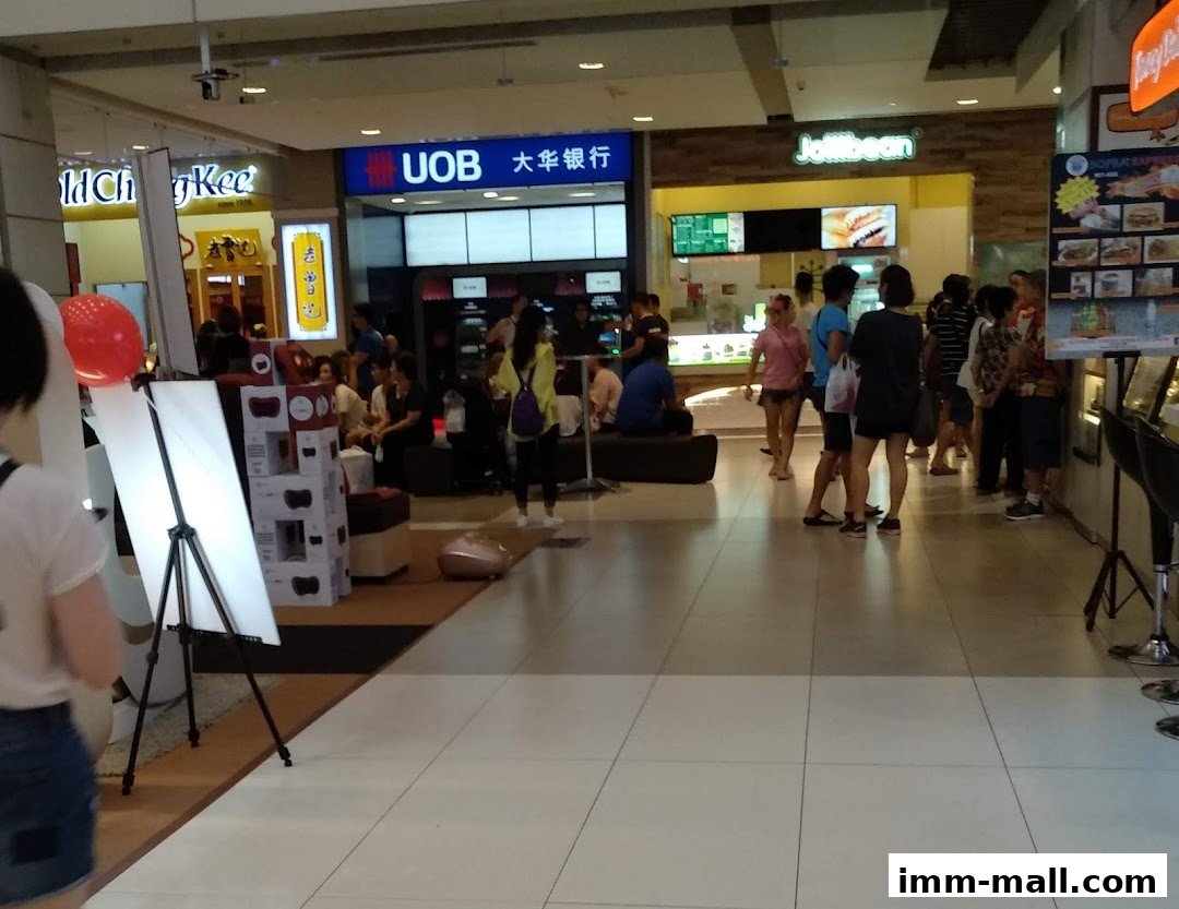 People gathered in a shopping mall near a UOB ATM and Jollibee.