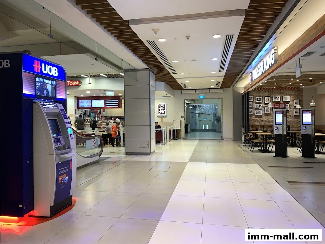 A UOB ATM and Burger King restaurant in a shopping mall corridor.