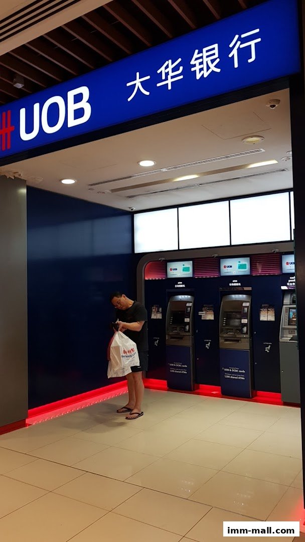 A UOB ATM area with multiple machines and a person standing nearby.