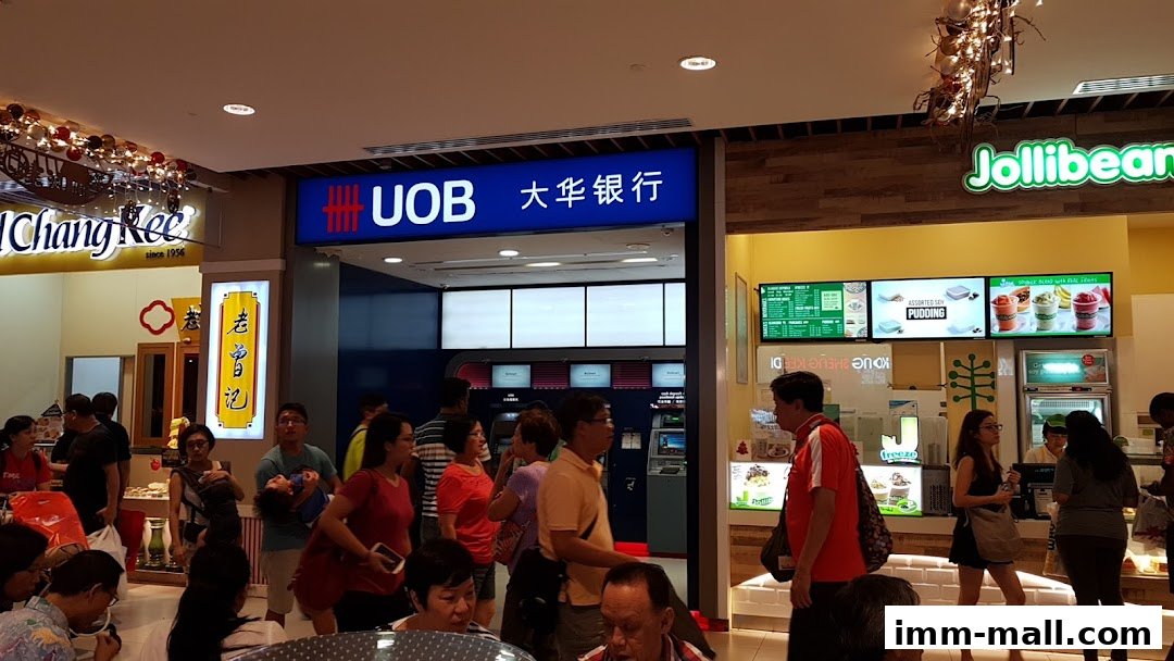 People gathered in front of a UOB bank and a Jollibee store in a mall.