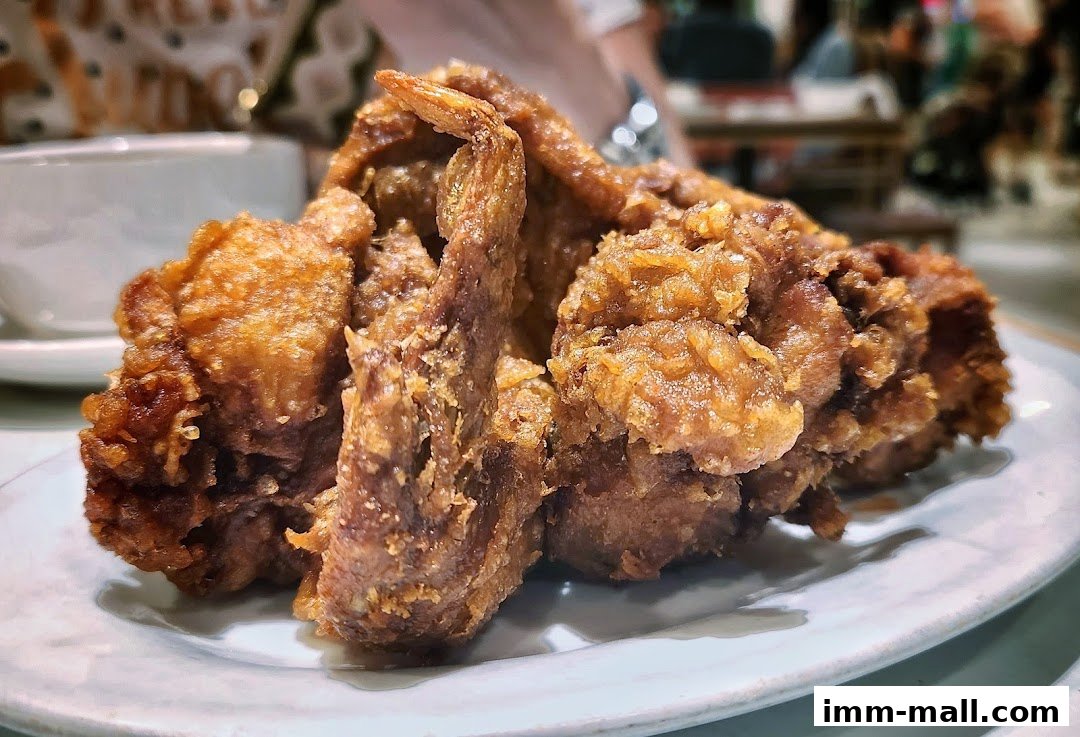 A close-up shot of crispy, golden-brown fried chicken on a white plate.