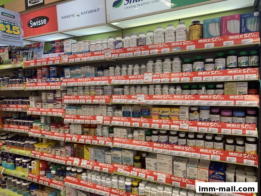 Shelves stocked with various health supplements and vitamins, many with 'Buy 2 Get 50% Off' promotions.