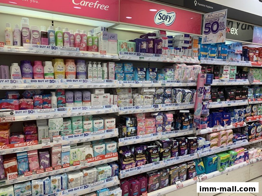 Shelves stocked with feminine hygiene products and personal care items from various brands.