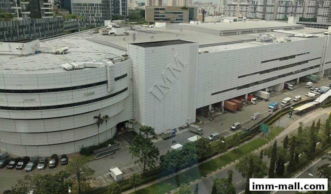 Exterior view of the IMM building with trucks and cars parked outside.