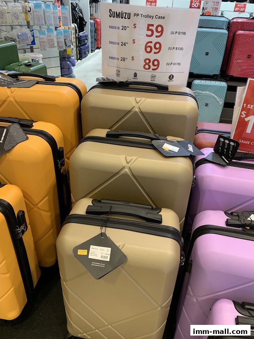 A display of colorful SUMŪZU PP trolley cases in various sizes with sale pricing.