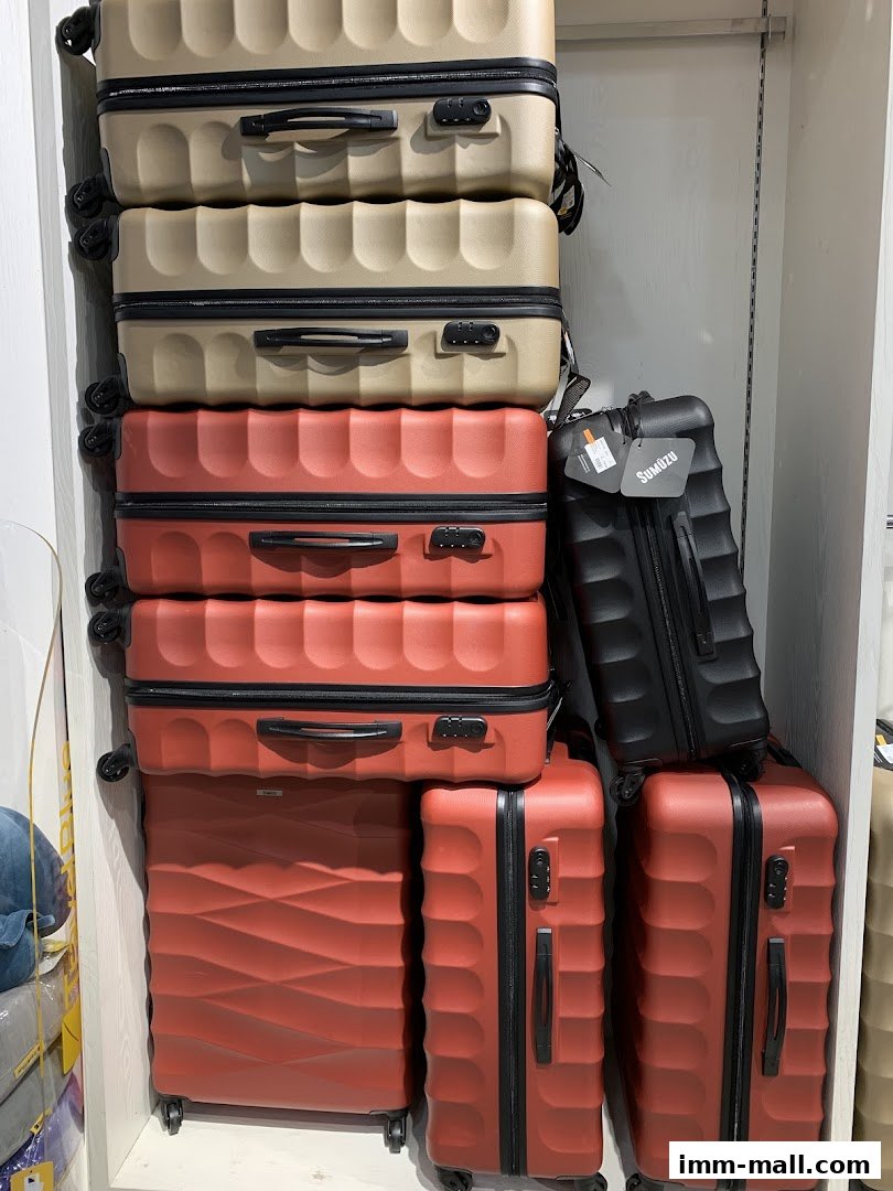 A display of various suitcases in different colors and sizes, stacked on shelves.