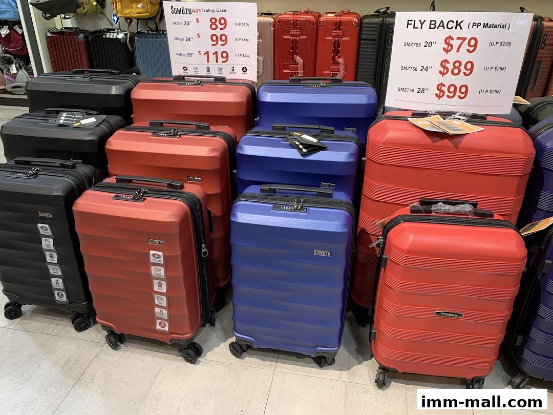 A display of various colored trolley cases, including red, blue, and black, with price tags.