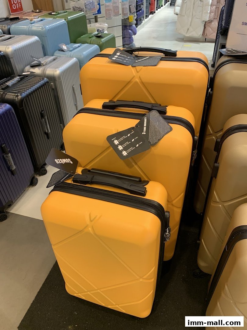 A display of various colorful suitcases, with a focus on bright yellow ones in the foreground.