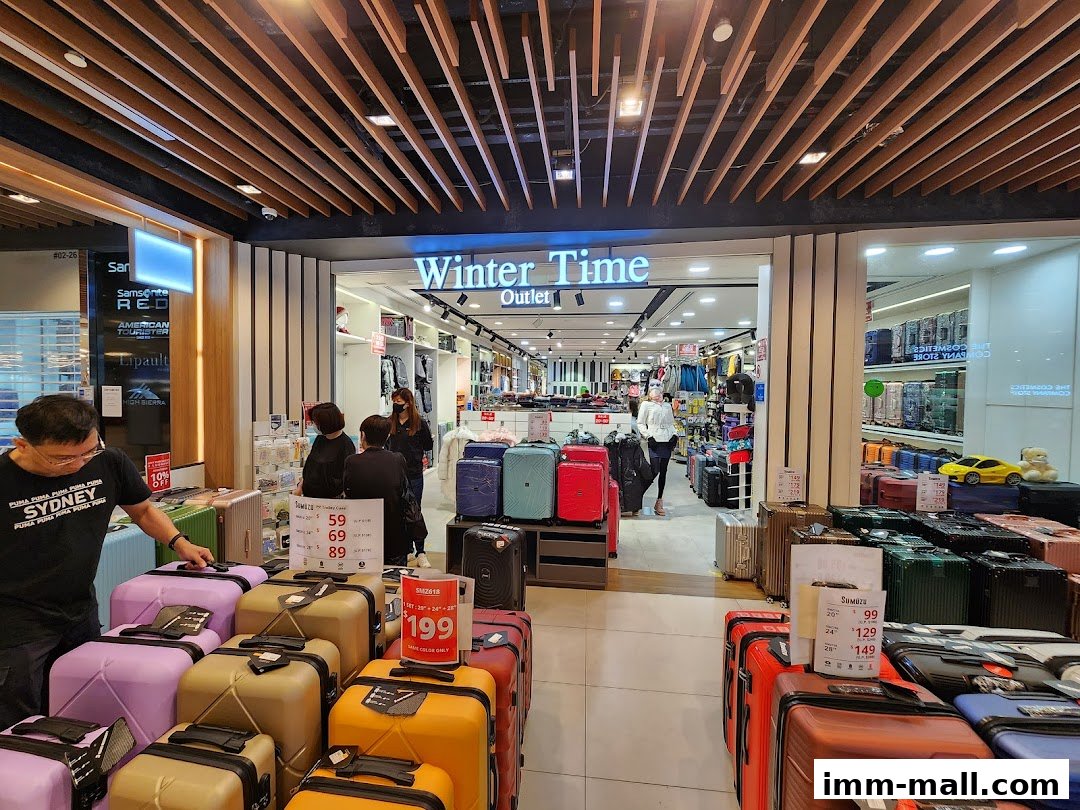A shop interior displaying a wide variety of luggage and travel bags, with promotional signs.