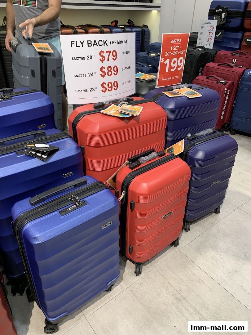 A display of colorful suitcases, with price tags and promotional signs.