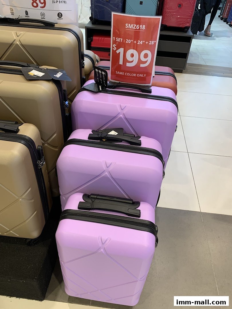 A display of luggage sets in various colors, with a price tag for a set.