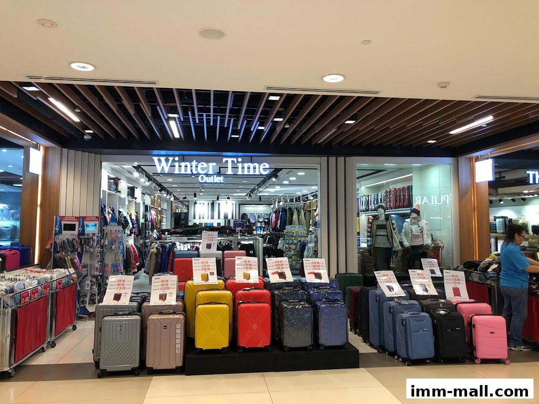 A retail store displaying a variety of luggage and apparel, with a focus on suitcases.