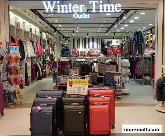 The entrance of Winter Time Outlet shop, showcasing winter clothing and luggage.