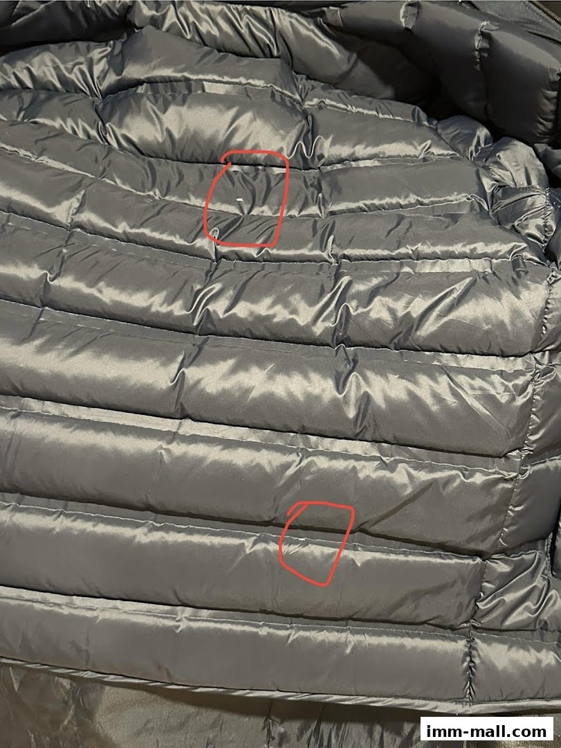 Close-up view of the quilted interior lining of a gray puffer jacket.