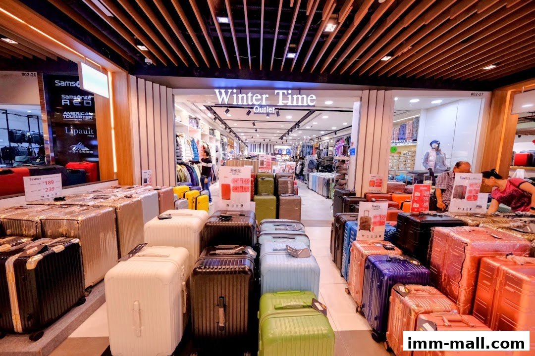A wide selection of colorful luggage is displayed outside the Winter Time Outlet store.